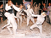 An outrageous finale to a muddy wrestling event that leaves the babes gasping for air and covered in slick, gray clay, some with their clothes on, and others wearing only tattered rags after their energy-filled catfights.