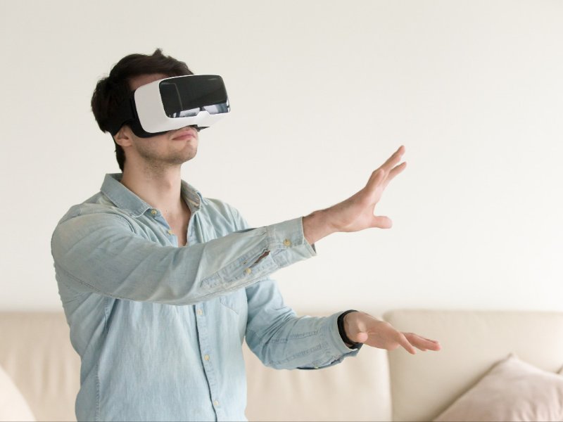 Young man wearing virtual reality glasses VR headset smartp