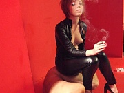 Smoking lady in latex uses her slave as an ashtray