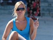 Smoking blonde in mini spyed, up skirt sitting