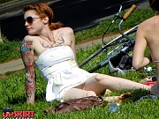 Tattooed redhead voyeured in a park. Sexy upskirt