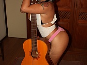 Brazilian model Andria Zammi posing her huge natural latin boobs with a guitar inside her flat