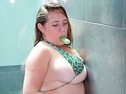 Blonde brazilian babe Silvia Calibresa posing her massive big tits in bikini while taking a bath.