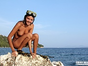 Adorable teen diver in flippers and swim mask showing off incredible nude body on the seaside.