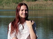 Incredible long haired redhead teen girl posing in the nude on the river in this video.