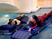 Two sexy clothed lesbian chicks fucking on floatable beds