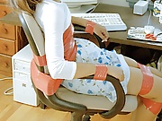 Young brown-haired beauty is "all tied up" at the office